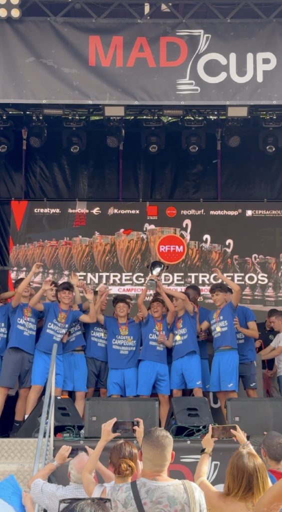 Jugadores del equipo Cadete B levantando el trofeo de campeones en MADCUP 2025 durante la ceremonia de entrega de premios.